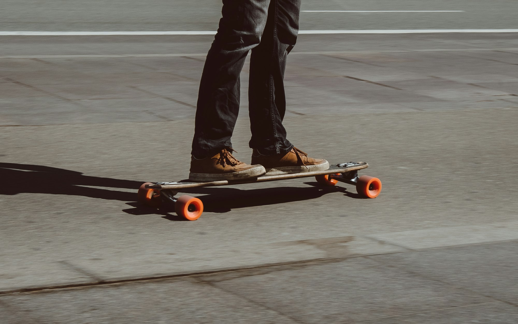 Guy cruising on his longboard on a sunny day in Copenhagen.