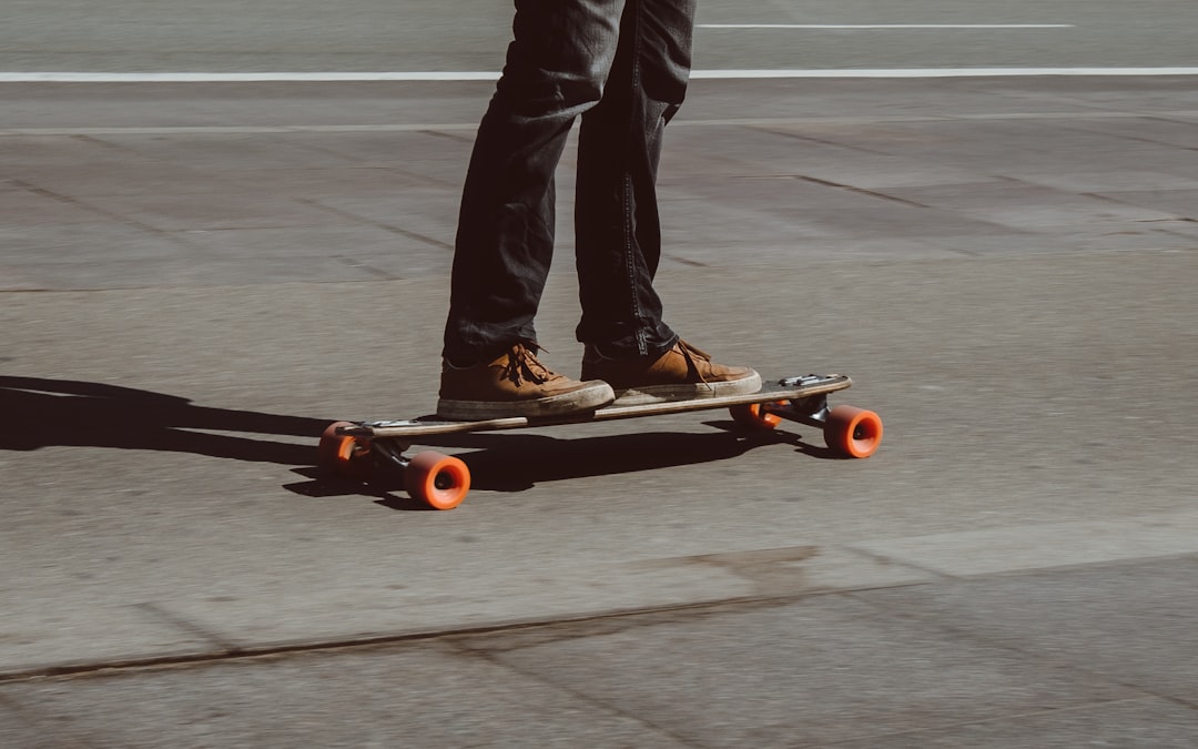 person riding skateboard on road, Guy cruising on his longboard on a sunny day in Copenhagen.
