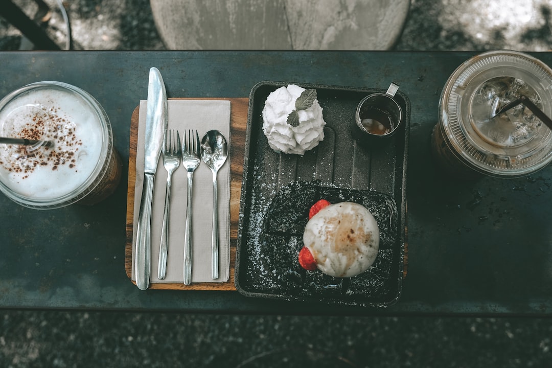 flat-lay photography of frappe cup beside cutlery and platter