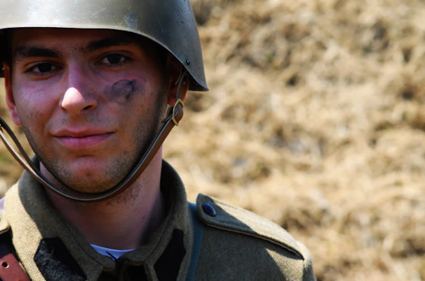 A soldier wearing a refurbished combat helmet standing in a training field.