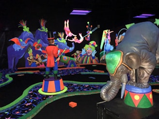 A vibrant, colorful scene reminiscent of a circus with playful elephants, clowns, and acrobats performing. The bright neon colors contrast against a dark backdrop, creating an energetic and whimsical atmosphere. Various performers, including a ringmaster in a red coat, are engaging in entertaining acts, and the scene is filled with detailed, exaggerated circus elements.