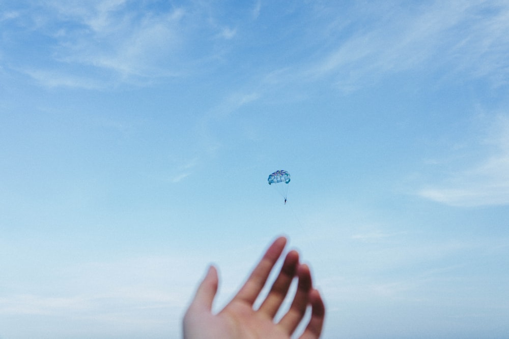 person riding parachute at daytime