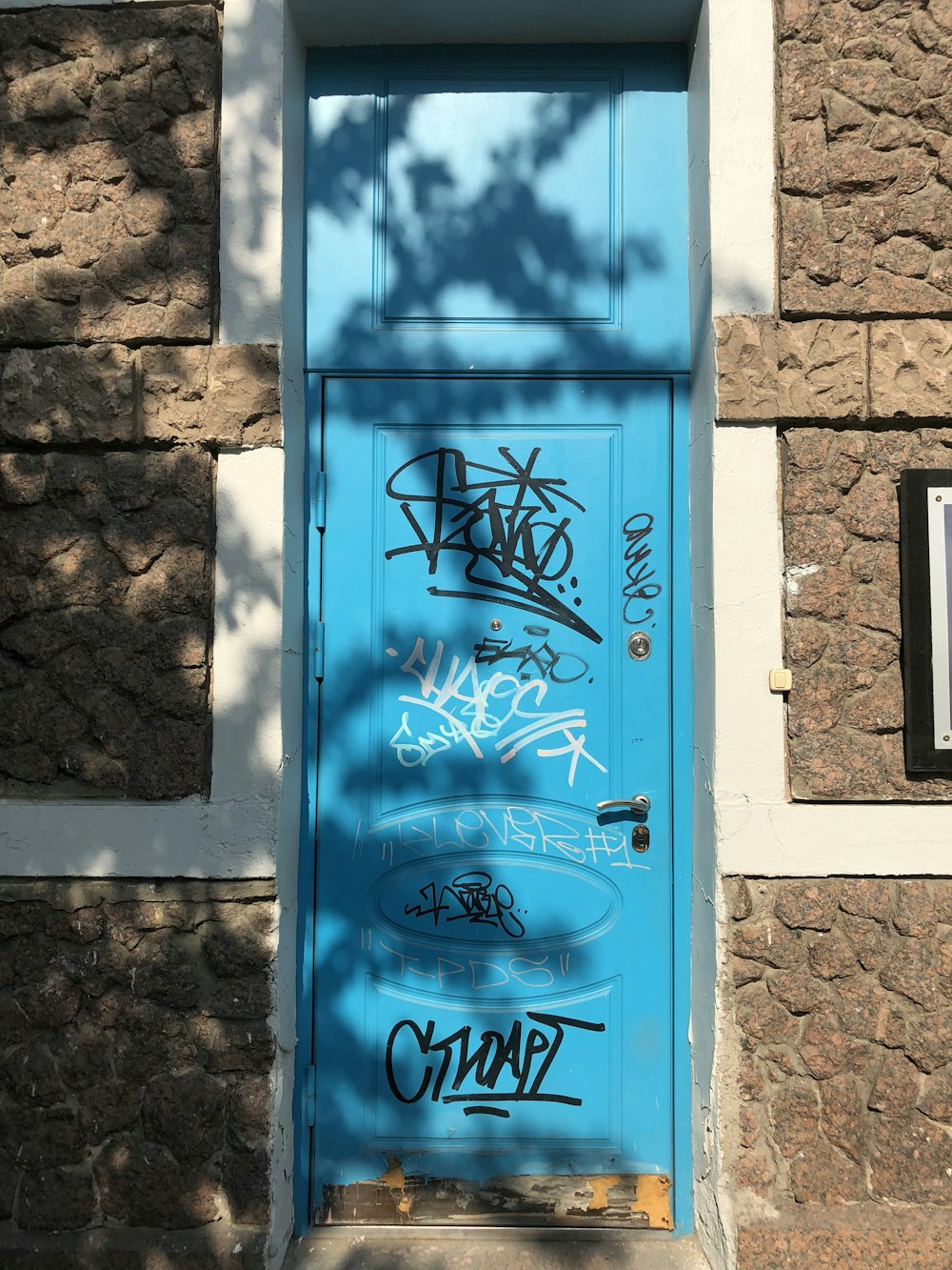 blue wooden door on brown concrete wall