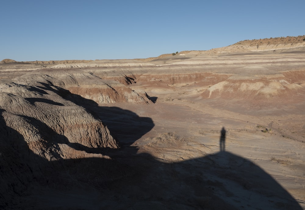 formação de terra com a sombra de uma pessoa durante o dia