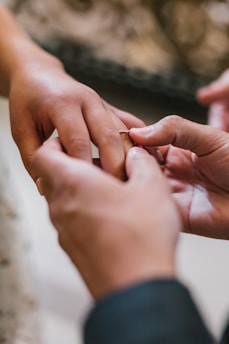 selective focus photography man attempting to put ring in woman's ring finger
