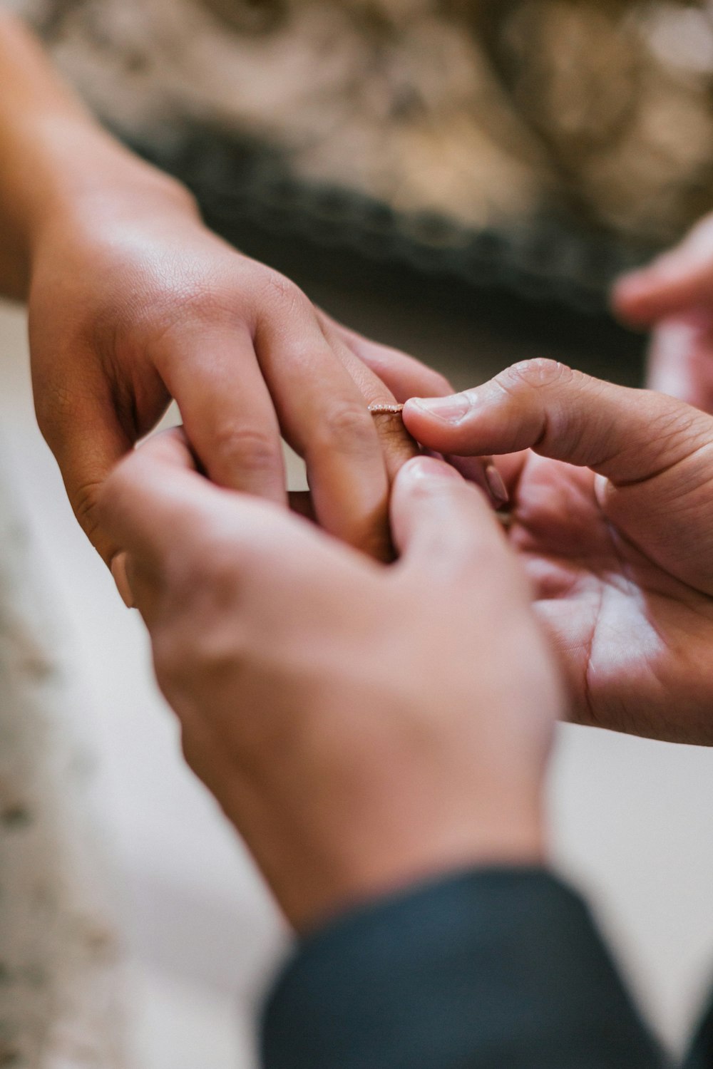 Hombre de fotografía de enfoque selectivo que intenta poner el anillo en el dedo anular de la mujer