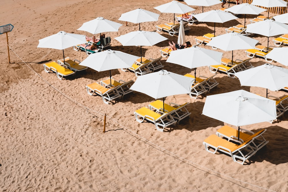 Liegestühle mit Sonnenschirmen am Strand
