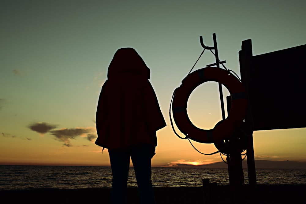 silhouette person standing near sea