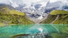 body of water with green mountains during daytime