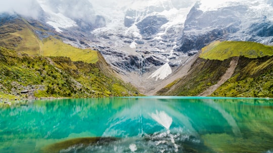 body of water with green mountains during daytime in Mountain Machu Picchu Peru