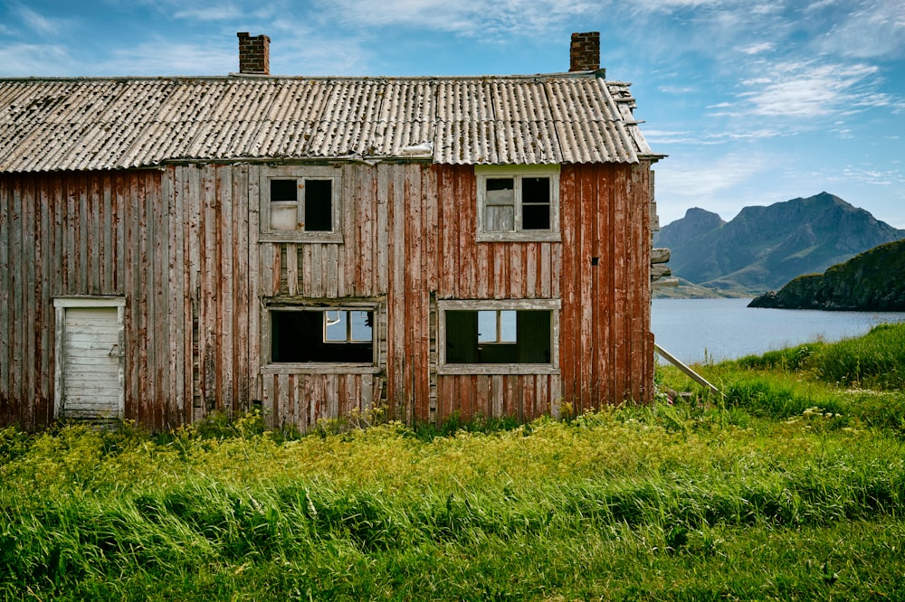 brown wooden 2-storey house in front of a body of water