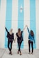 three woman holding hands white walking
