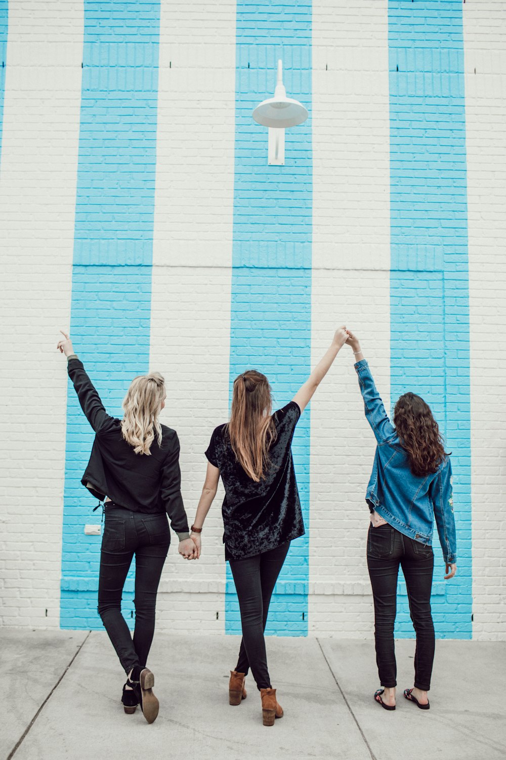 three woman holding hands white walking