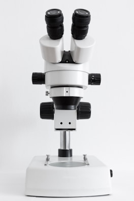A modern laboratory microscope with clear glass lenses and adjustable knobs.