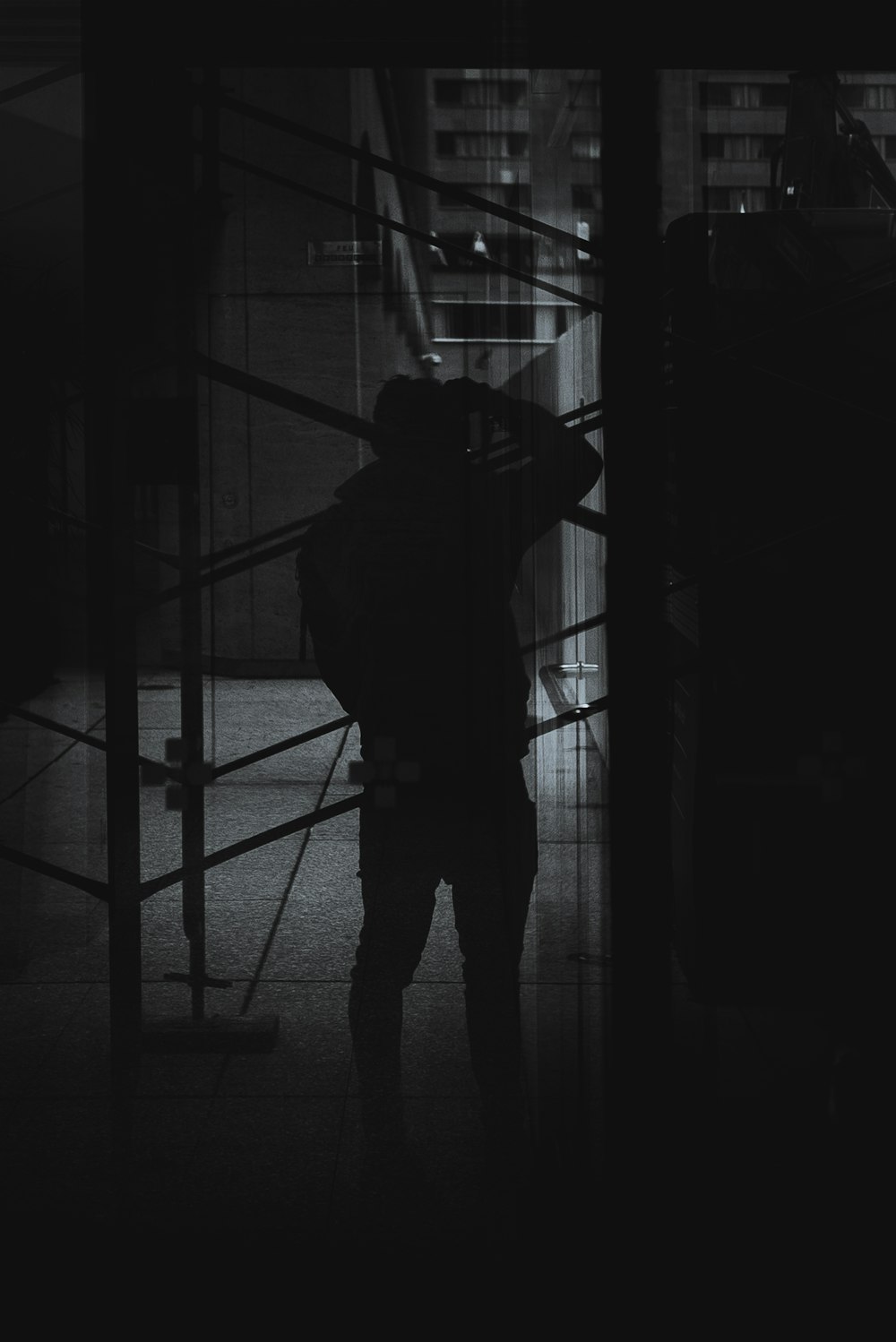 a person standing in front of a window in the dark