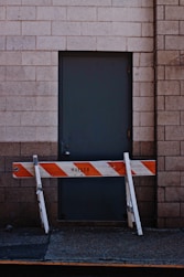 white and orange wooden fence beside black door