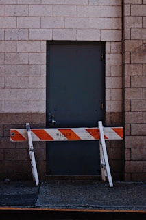 white and orange wooden fence beside black door