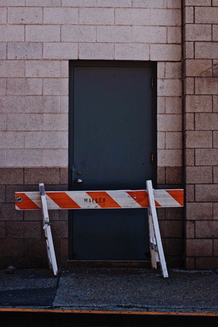 white and orange wooden fence beside black door
