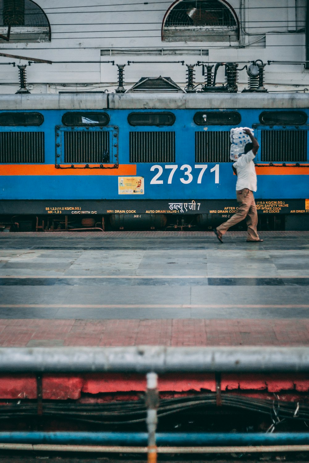 man carrying pack of bottles beside train station