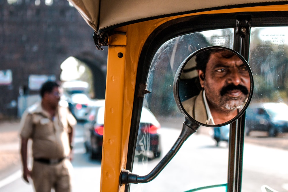 driver's face reflecting on mirror