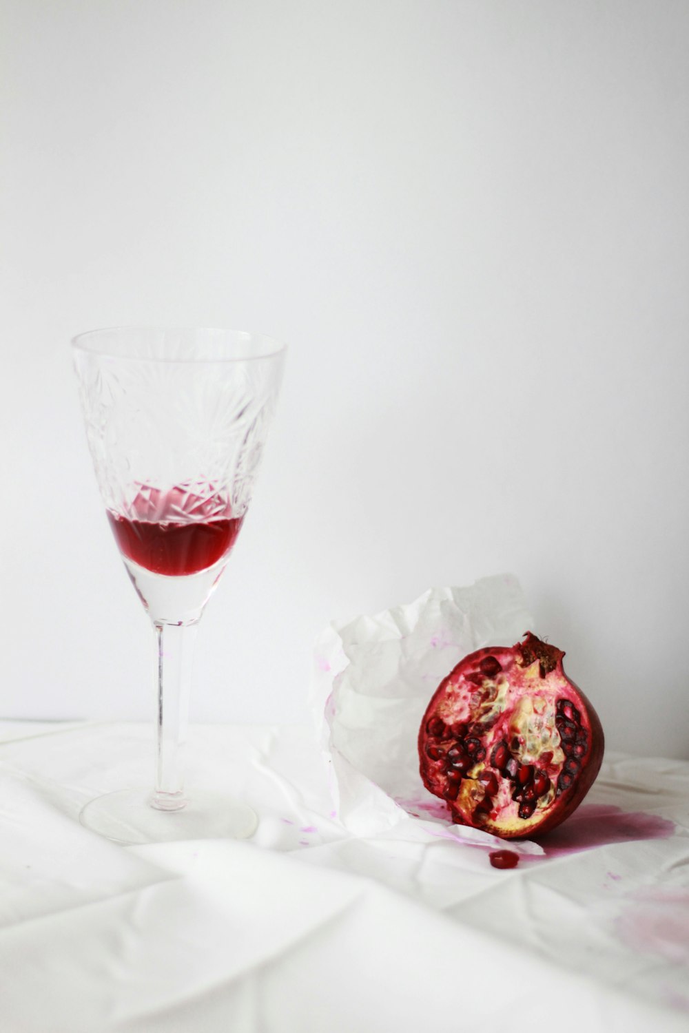 clear cut wine glass beside pomegranate