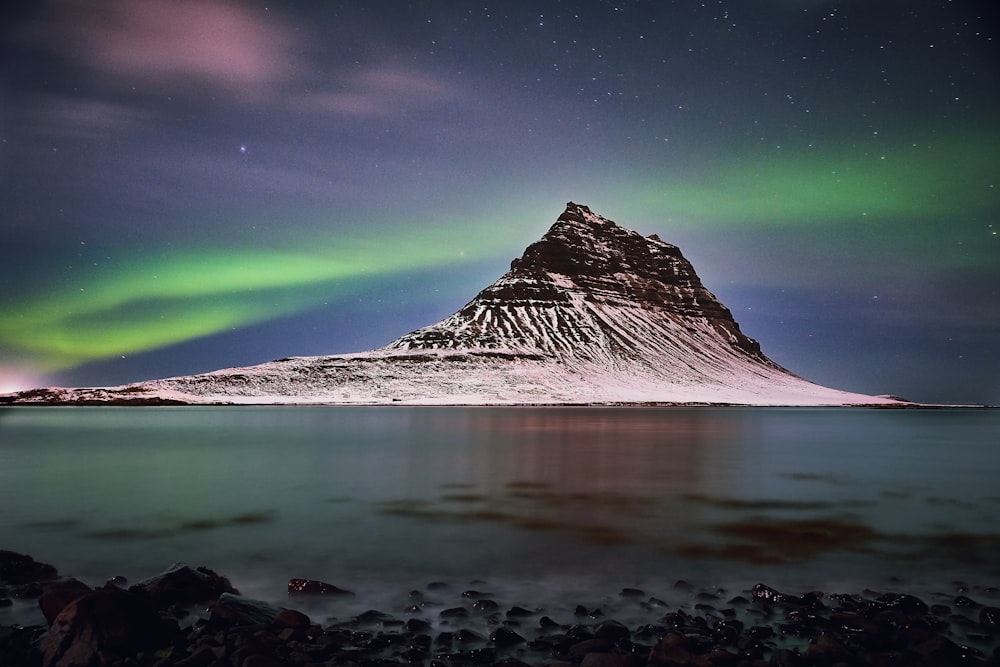 snow capped mountain under aurora