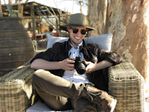 man sitting on chair while holding camera