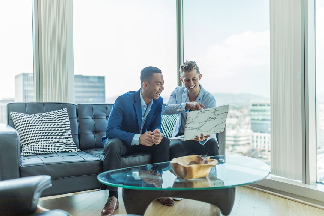 Two men seated on a couch, discussing strategies for account planning using data and analytics.