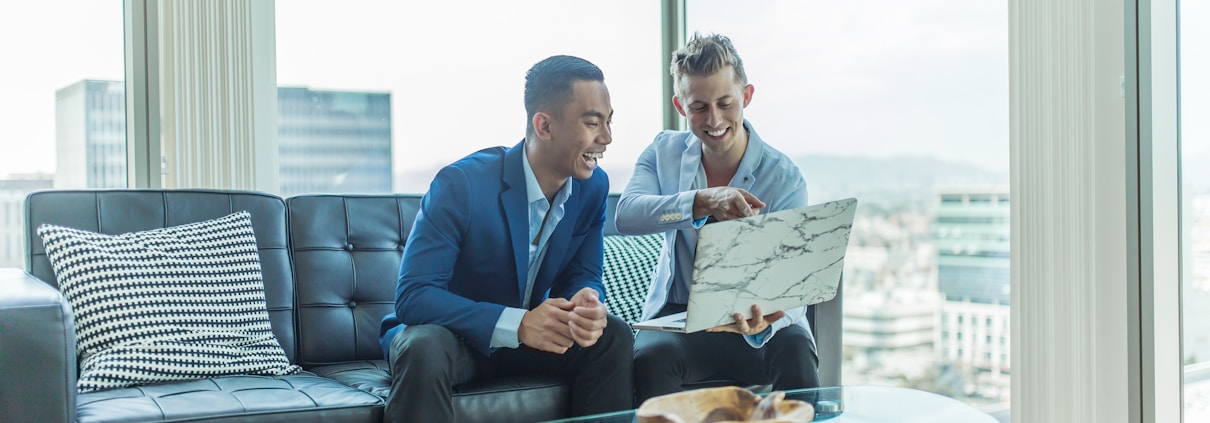 MLM two men in suit sitting on sofa