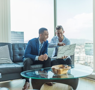 two men in suit sitting on sofa