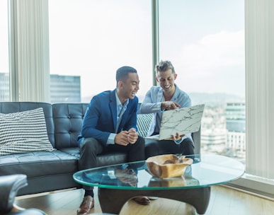 two men in suit sitting on sofa