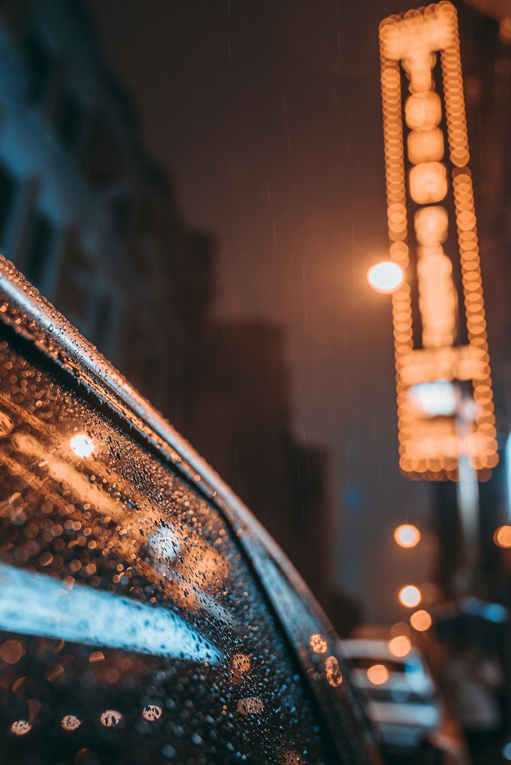 a rainy night in a city with a neon sign in the background