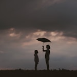 girl holding umbrella on grass field