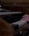Close-up of a musician’s hands skillfully arranging sheet music in a cozy studio setting.