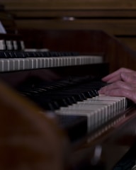 Close-up of hands playing piano keys in a cozy studio setting.