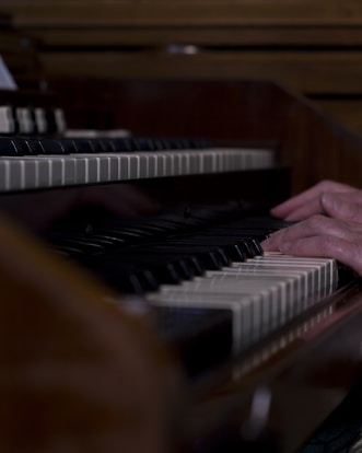 A close-up of hands playing piano keys in a cozy studio setting.