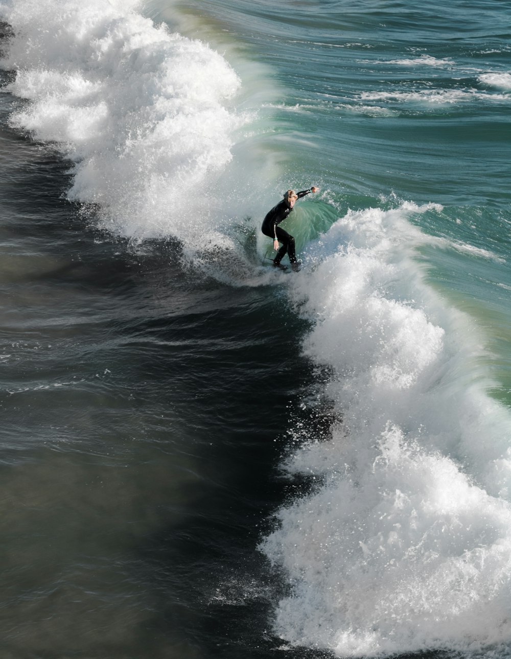 昼間に海の波でサーフィンをする人