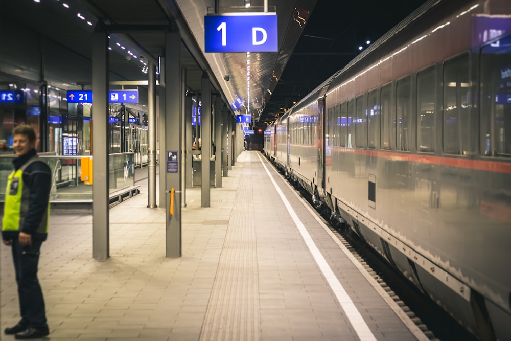 man standing near train inside train station