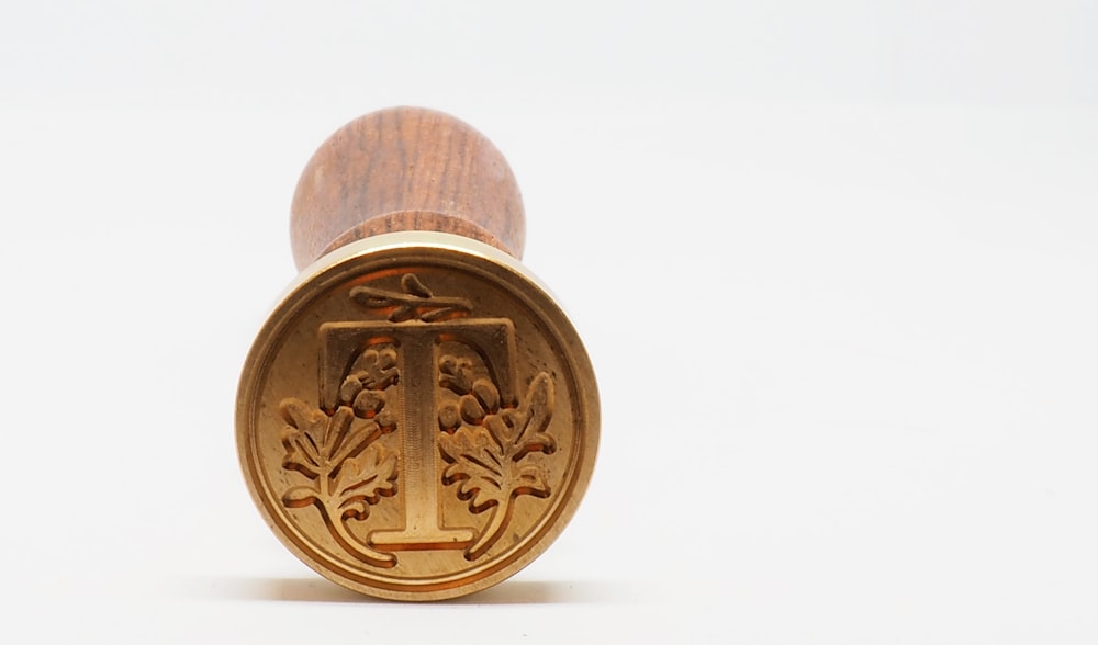 round gold-colored coin on white surface