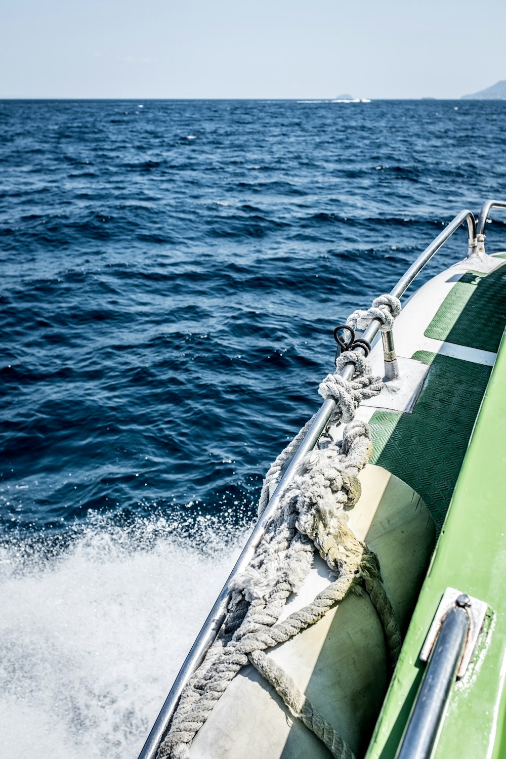 海を航行する緑と白のボート