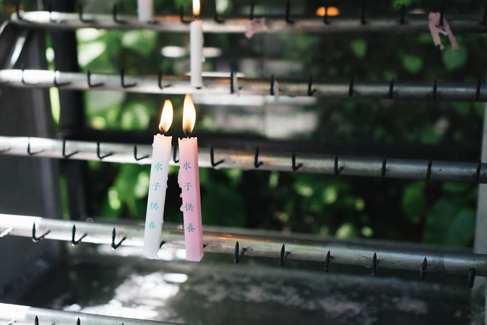 two lighted pink and white candlesticks