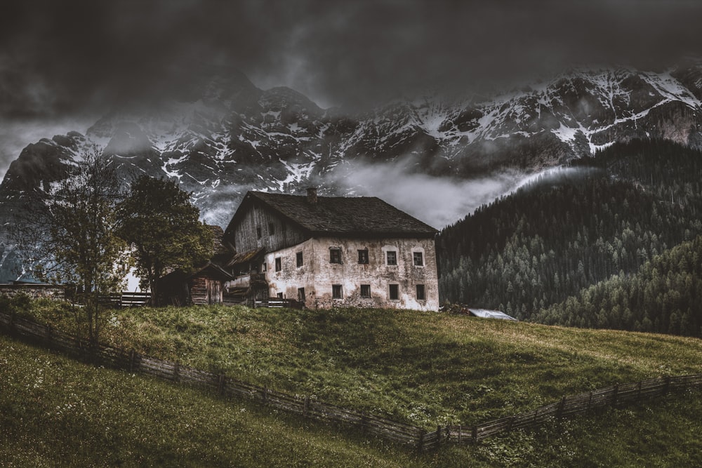 house on top of hill near mountain alps