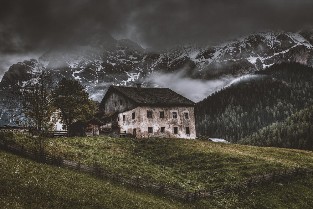 Casa en la cima de una colina cerca de los Alpes montañosos
