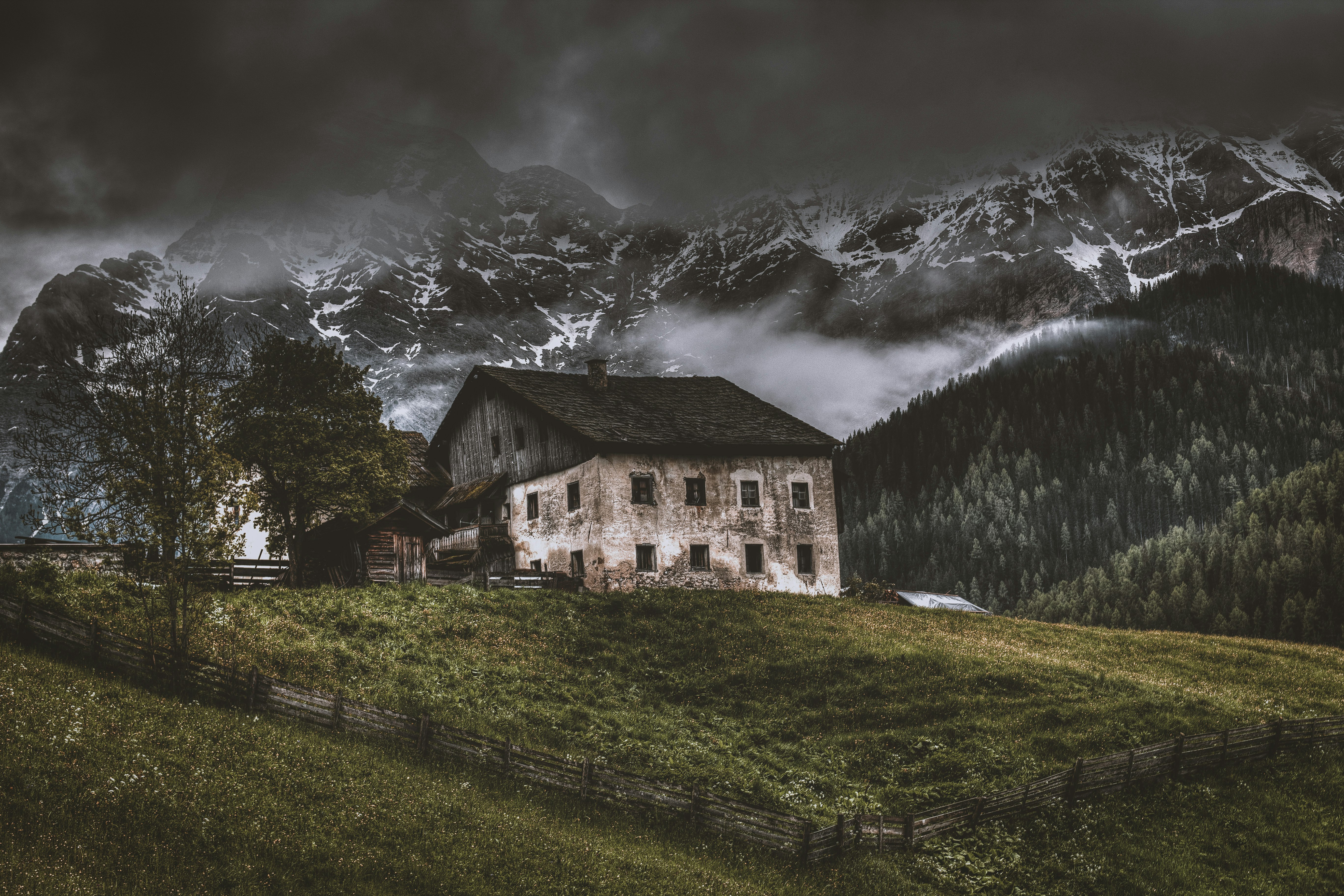 house on top of hill near mountain alps