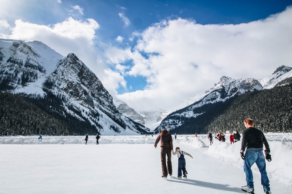 people wearing ice skates with mountain at the distance