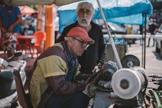Two friendly local handymen smiling while working on a home repair in a sunny Tenerife neighborhood.