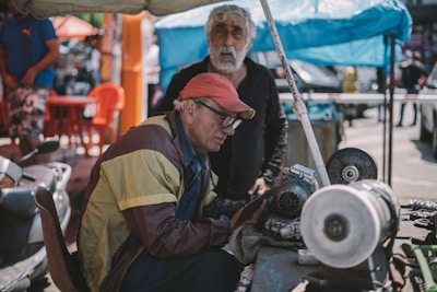 Close-up of technical engineers inspecting mechanical components outdoors.