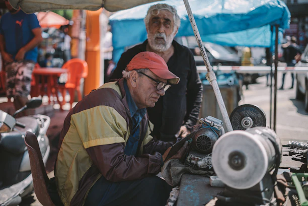 Two brothers working together to clean a vacuum machine in a cozy workshop.
