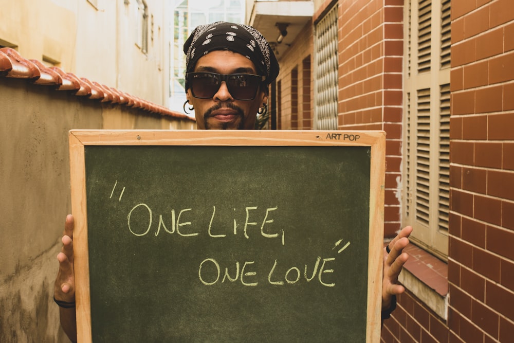 man holding one life one love board