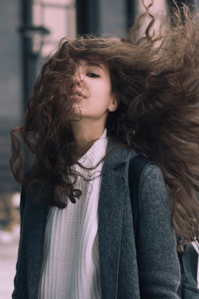 a woman with wind blowing through her hair extensions